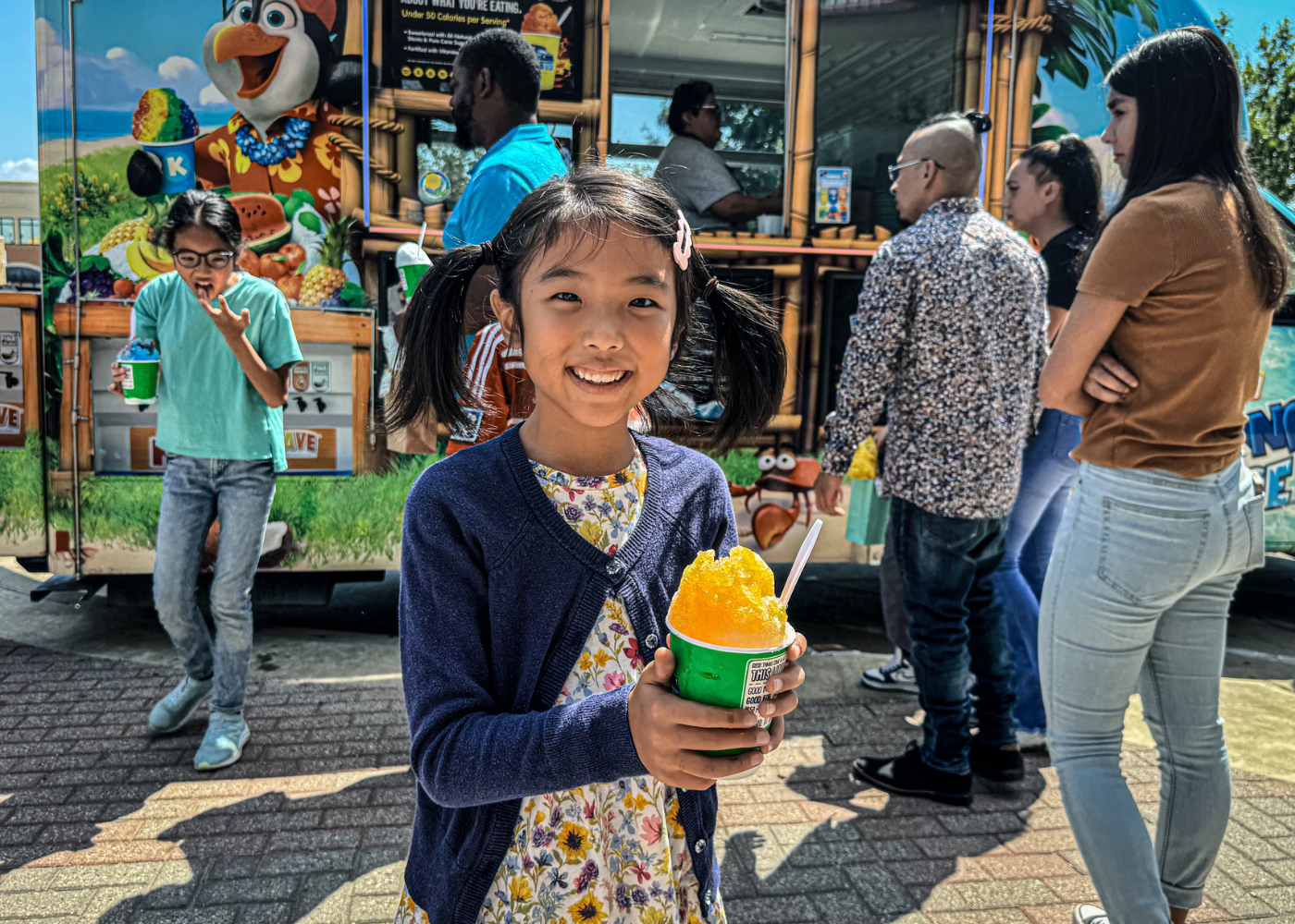 kids ministry girl's left hand wrap around toddler while reading book during golden hour